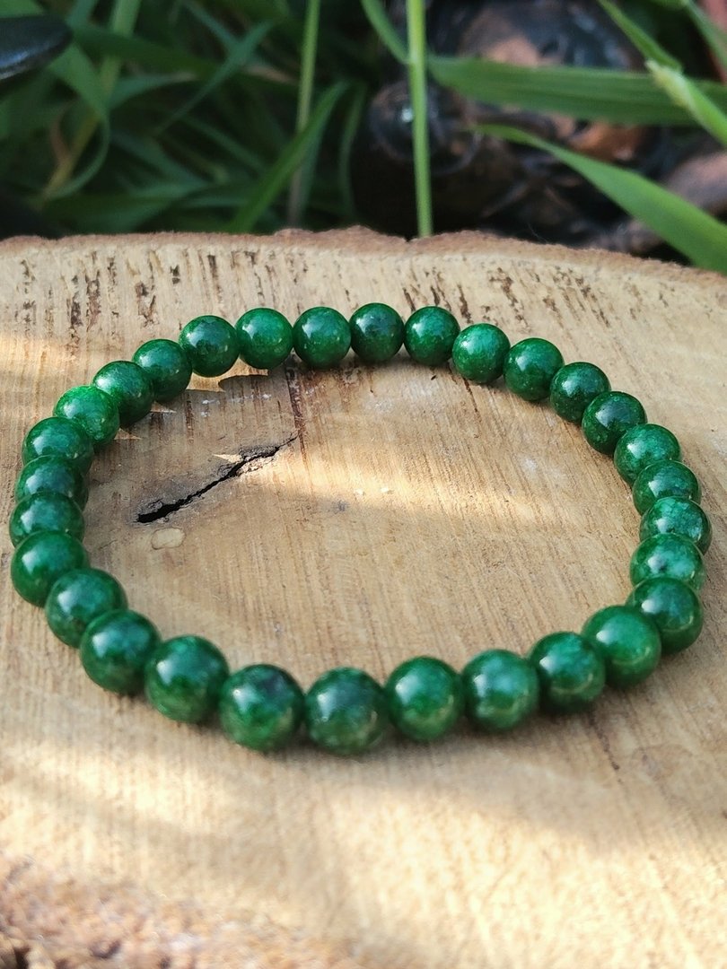 bracelet-jade-africain-perles-rondes-6-mm-pose-sur-support-clair-texture-avec-feuillage-vert-en-arriere-plan-bienfaits-apaisement-ancrage-stabilite-emotionnelle.jpeg Bracelet jade africain - 6 mm – Image 1