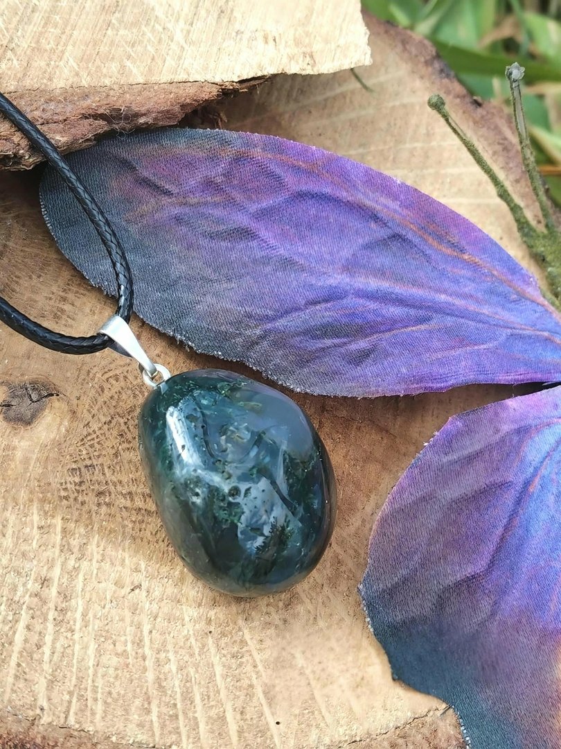 pendentif-agate-mousse-pierre-naturelle-vert-bleute-monte-sur-cordon-noir-photographie-sur-tranche-de-bois-avec-grande-feuille-violette-en-decor-chakra-du-coeur-apaisement-serenite.jpeg Pendentif agate mousse – Image 1